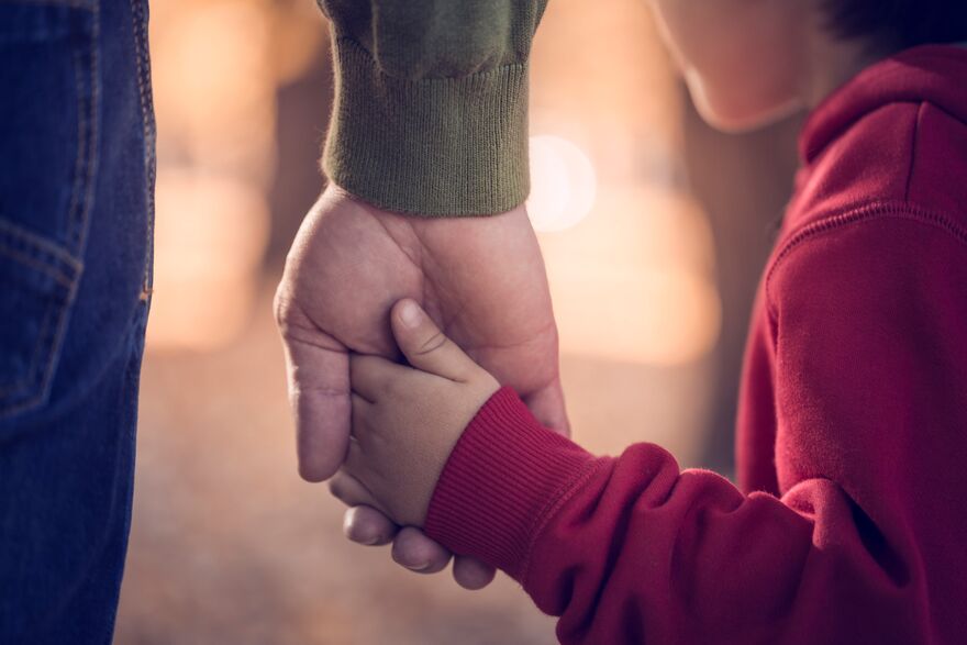 Child holding hands with parent - SA Law's Dignified Divorcee